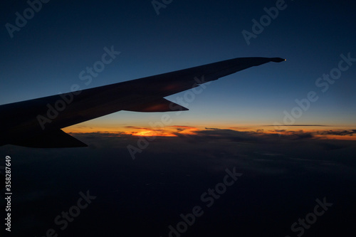 Flight on a plane sunset behind the wing of the plane.