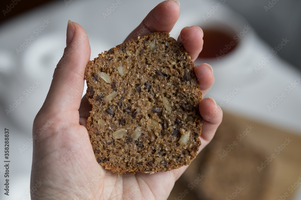 a slice of bread holds a female hand close-up
a slice of bread holds a female hand close-up