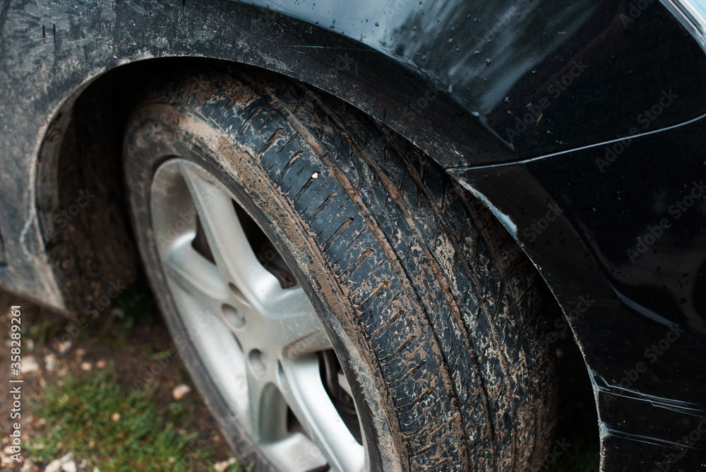 Close up photo of dirty car and tires in a rainy day