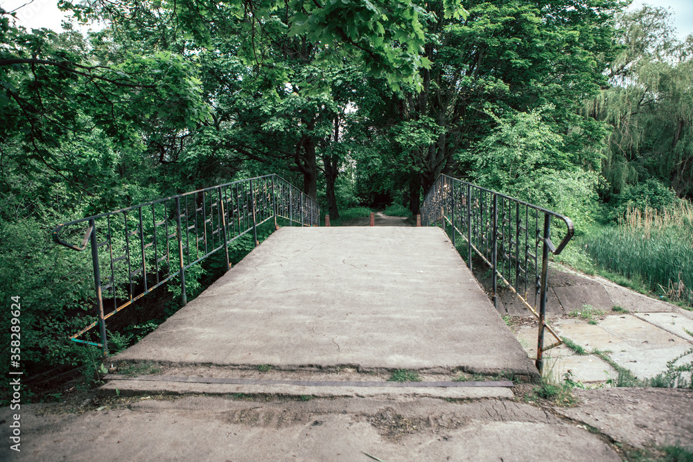 the view of the pedestrian bridge across the Creek in the Park the view of the pedestrian bridge across the Creek in the Park