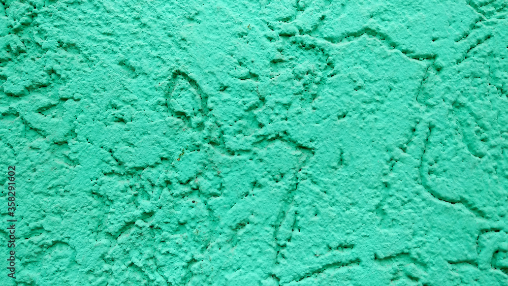 Emerald green wall with patterned plaster paint background Emerald green wall with patterned plaster paint background