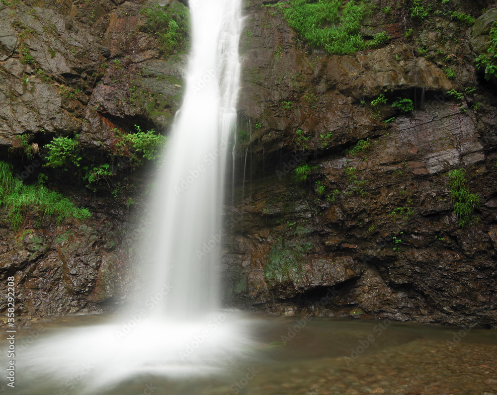 Fototapeta premium Waterfall near Buddhist temple at the head of a Japanese river.
