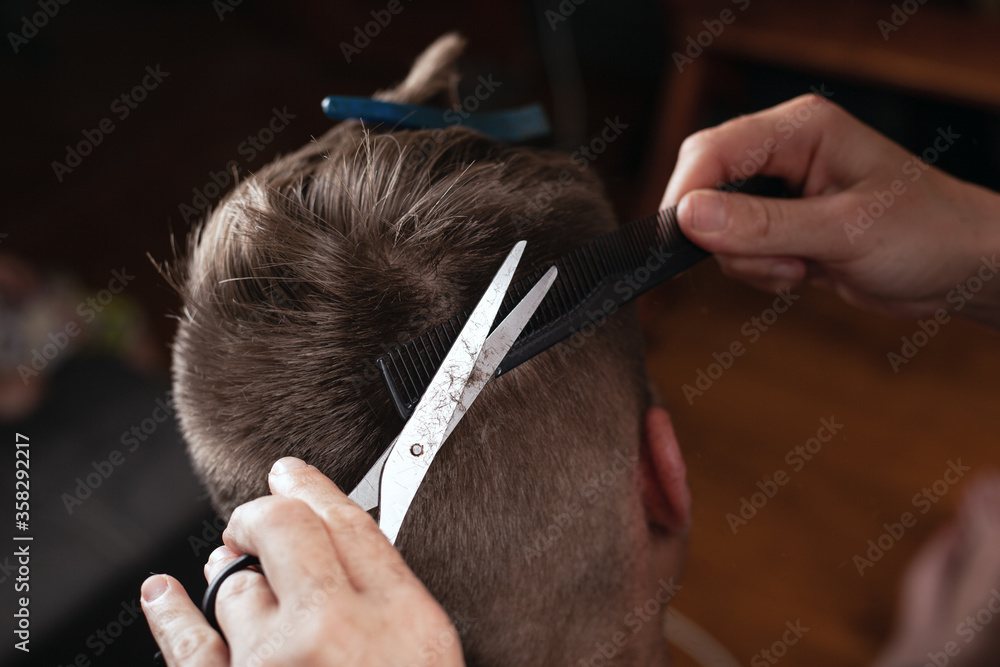 hand cutting hair with a comb and scissors.hairdresser makes fashionable hairstyle to client hand cutting hair with a comb and scissors.hairdresser makes fashionable hairstyle to client