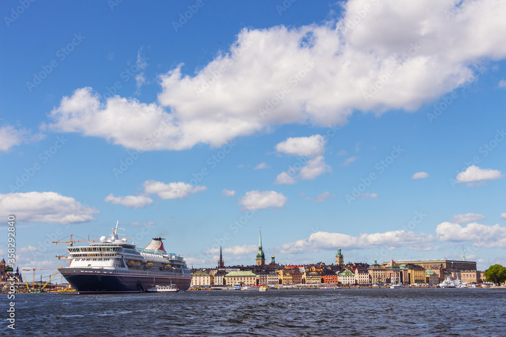 Panoramic view of Stockholm, Sweden. The view from the water. A large passenger cruise ship. A beautiful European city under a blue sky with white clouds.