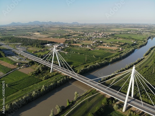 Aerial view of a modern bridge over a river in northern Italy.