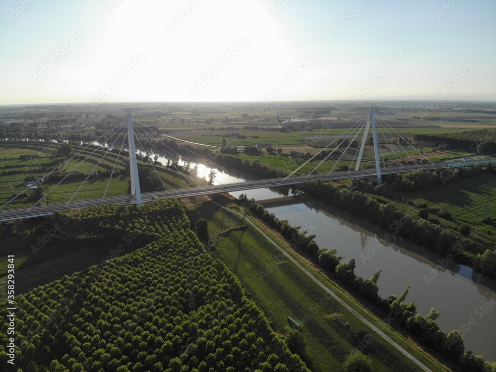 Aerial view of a modern bridge over a river in northern Italy.
