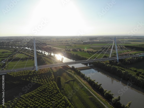 Aerial view of a modern bridge over a river in northern Italy.