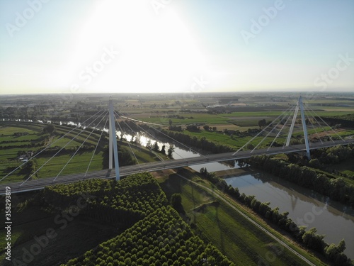 Aerial view of a modern bridge over a river in northern Italy.