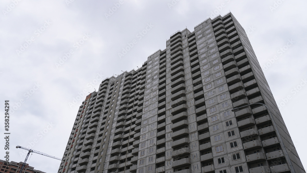 Large construction site on a background of blue sky. Brick, panel apartment building. Industrial theme for design Large construction site on a background of blue sky. Brick, panel apartment building. Industrial theme for design