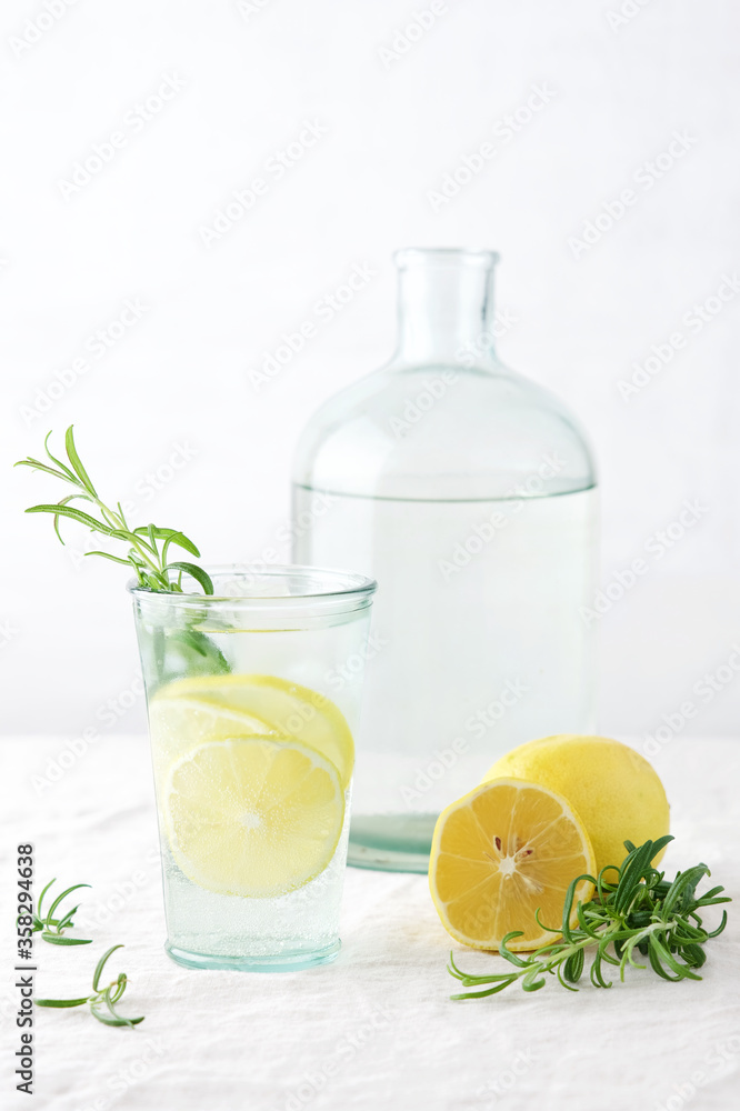 Lemon with rosemary summer cocktail or lemonade. Cold refreshment non-alcohol drink with lemon in glass