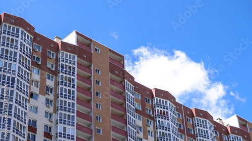 Large construction site on a background of blue sky. Brick, panel apartment building. Industrial theme for design © subjob
