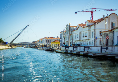 wide river that stretches in the city of Aveiro. houses over the river and clear blue water