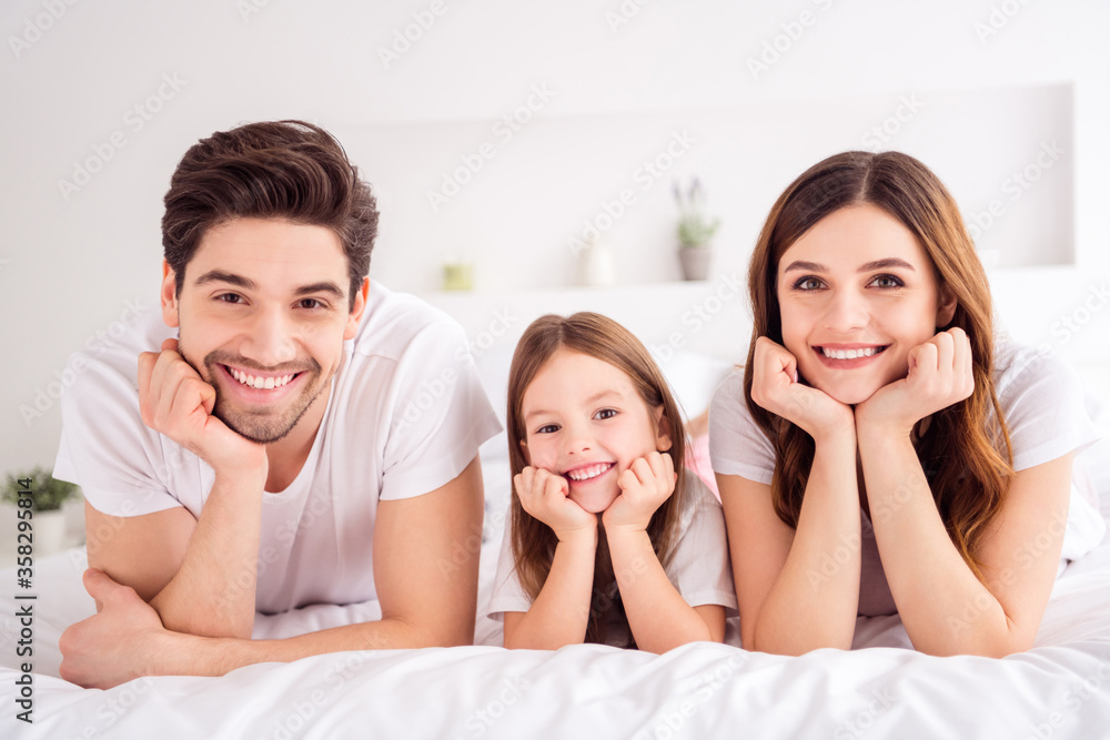 Photo of charming young lady guy little girl happy family lying sheets leaning hands head toothy smiling good mood spend time together quarantine self isolation bedroom indoors Photo of charming young lady guy little girl happy family lying sheets leaning hands head toothy smiling good mood spend time together quarantine self isolation bedroom indoors