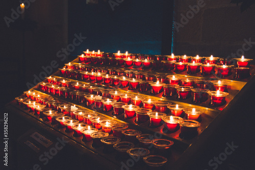 rows of lighted candles in the church. candle burning in the dark