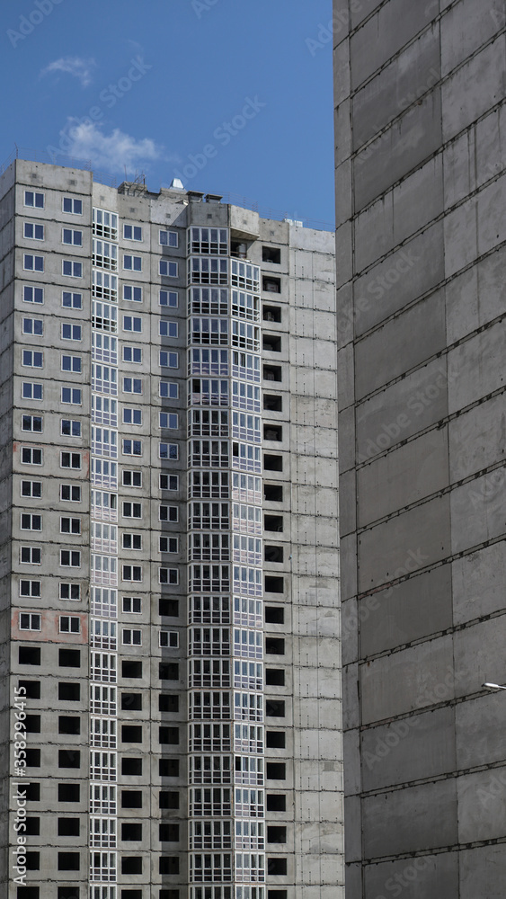 Large construction site on a background of blue sky. Brick, panel apartment building. Industrial theme for design