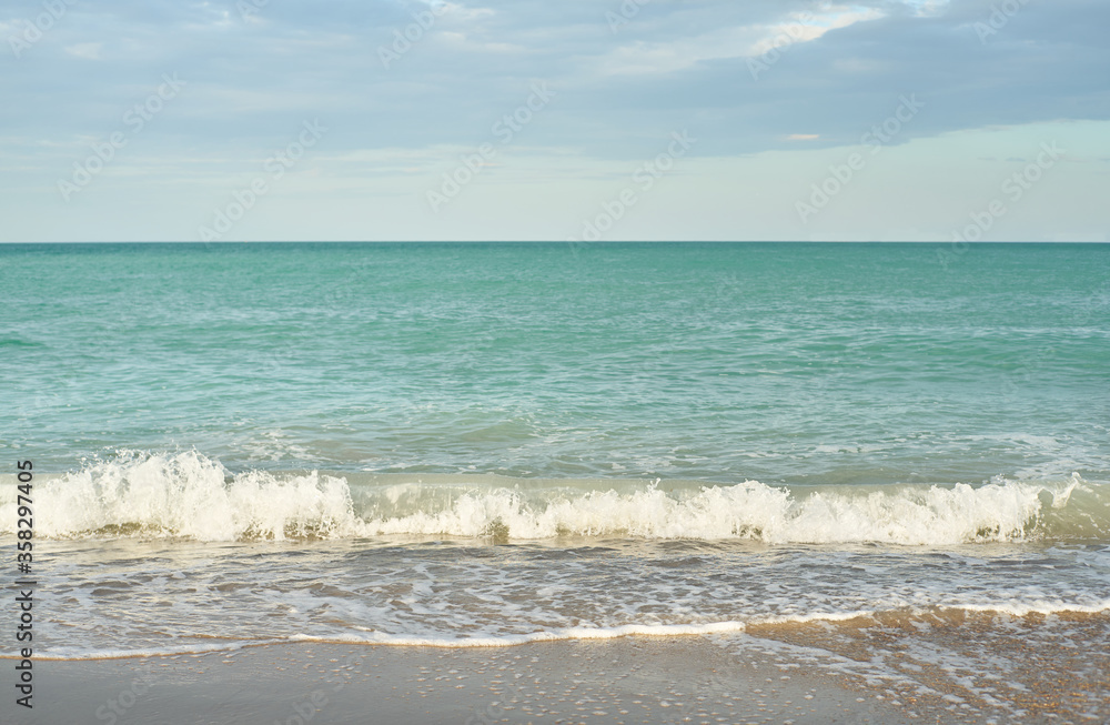 Sea waves on the beach at sunset