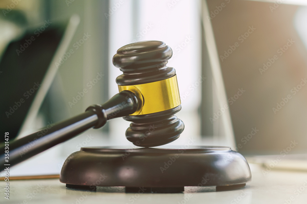 Wooden gavel is placed on the table in the notary office, Wooden gavel used to knock during a court decision. The legal team is currently providing advice and consulting within the law firm. Wooden gavel is placed on the table in the notary office, Wooden gavel used to knock during a court decision. The legal team is currently providing advice and consulting within the law firm.