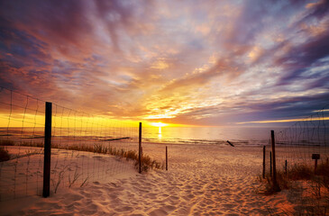 Fototapete Abstieg zum Strand Dramatischer Sonnenuntergang an der Ostseeküste  © MaciejBledowski