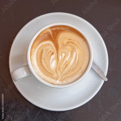 Italian cappuccino coffee cup top view on dark wood table background