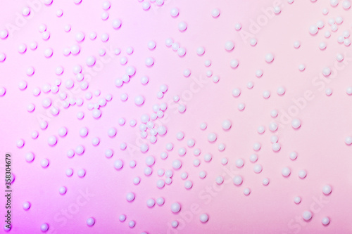 White balls on neon pink background. Trending background for beauty themes.