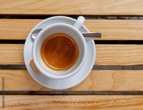 Italian espresso coffee cup top view on wooden stripes table background, space for text