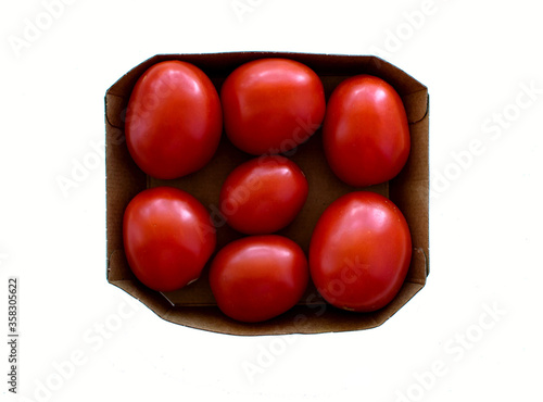 Red, bright, juicy, fresh tomatoes in container, isolated on white background.