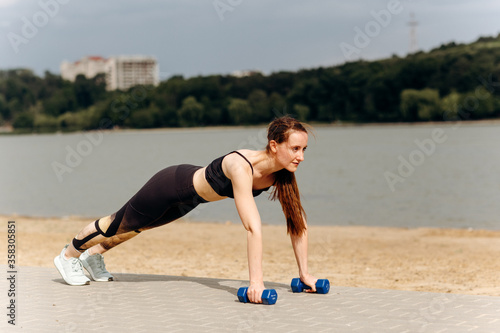 Young fit woman doing exercise on the sand beach