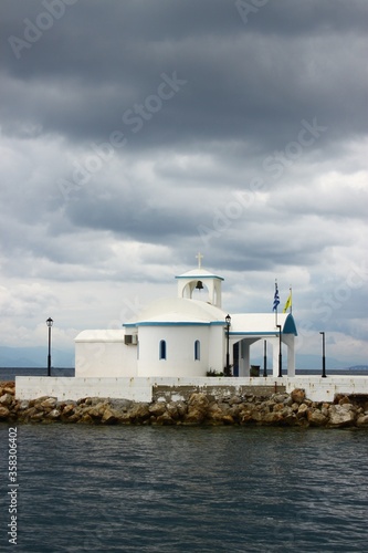 A church next to the sea under a cloudy sky