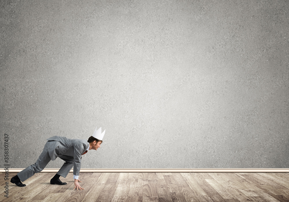 King businessman in elegant suit running in empty room King businessman in elegant suit running in empty room