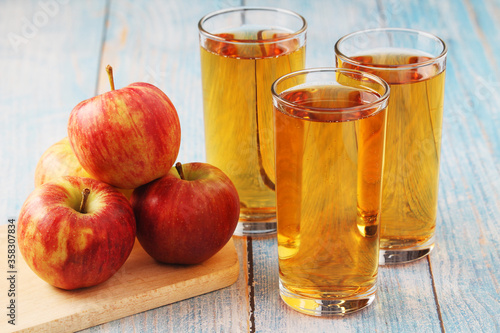 Glasses with apple juice and ripe apples