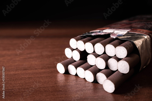 Tableau sur toile Brown cigarillos on a wood black background