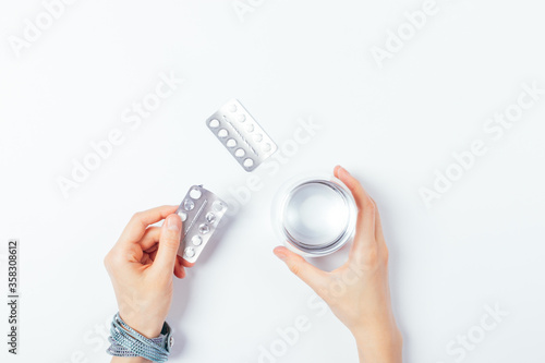 Top view of female hands holding pills