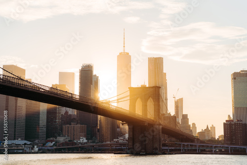 Manhattan and Brooklyn bridge skyline view with sunset and sun flare. World Trade center on background  photo