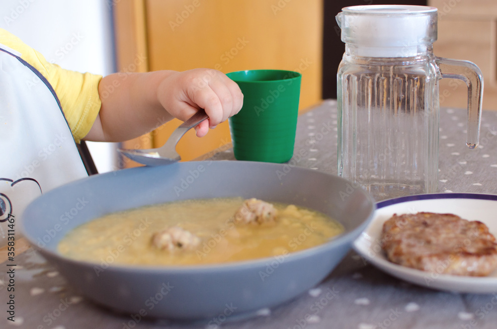 child eating soup with spoon child eating soup with spoon