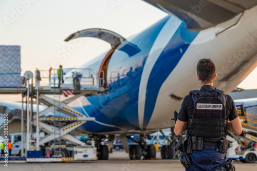 Déchargement d'un avion cargo médical sous la surveillance des forces de l'ordre de la Gendarmerie Nationale