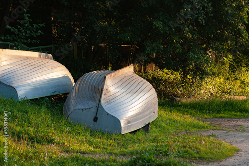 Photography Inverted wooden boats on the embankment in Moscow (Russia) in the rays of the ev
