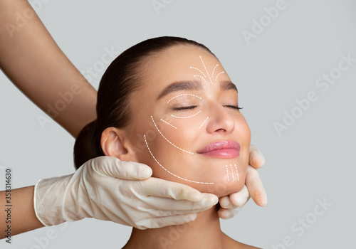 Calm girl receiving face massage from cosmetologist photo