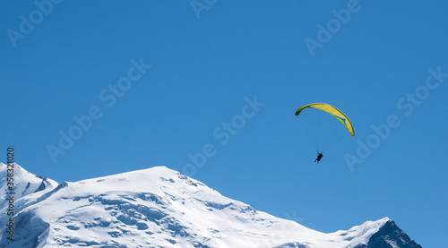 Paraglider and beautiful Mont Blanc mountain at background. Summer recreation attractions and tourism in Haute Savoie, France. Adventure, eco planet, climat change, environment, ecology concepts.