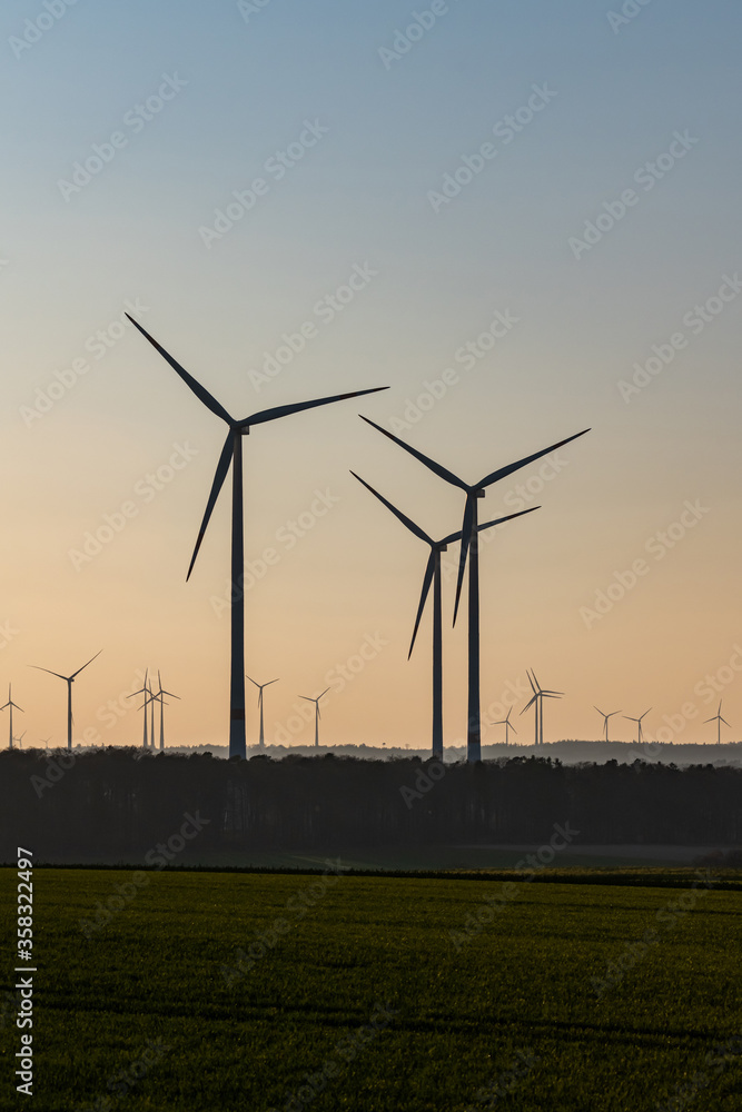 Black Silhouette of windturbines energy generator on amazing sunset at a wind farm in germany Black Silhouette of windturbines energy generator on amazing sunset at a wind farm in germany