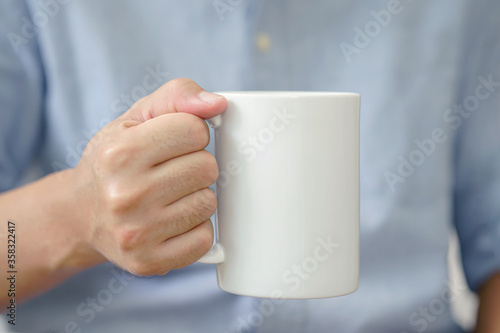 Mug mockup. businessman's hands holding mug with blank space for your text or promotional content.