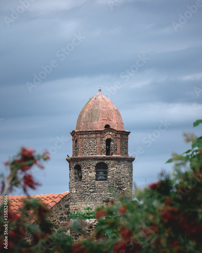The church tower in Collioure in the background on a gray sky day.
Le clocher de l'église à Collioure en arrière-plan un jour de ciel gris.
