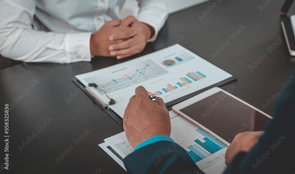 Asian business men and women are brainstorming and analyzing corporate financial graph data in the office. Asian business men and women are brainstorming and analyzing corporate financial graph data in the office.