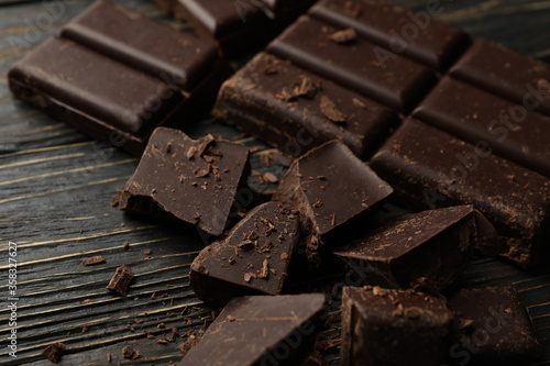 Chocolate pieces on wooden background, close up