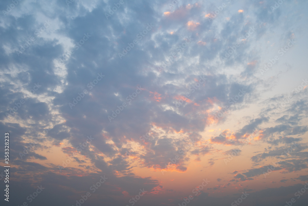Dramatic sky of golden or yellow sunset light with blue sky and white clouds at evening time Dramatic sky of golden or yellow sunset light with blue sky and white clouds at evening time