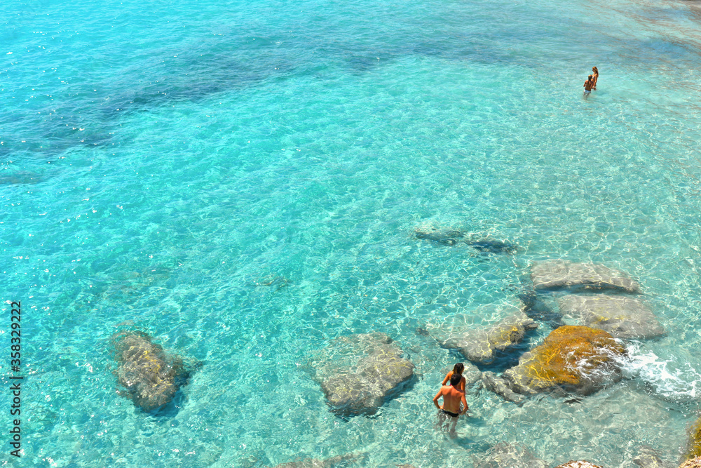  paradise clear turquoise blue water with rocks in Favignana island, Cala Azzura Beach, Sicily South Italy.