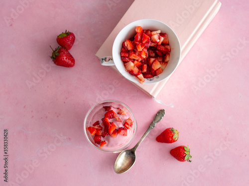 Strawberry ice cream in a glass cup on a pink background. Yogurt ice cream. Diet, healthy eating. Fresh strawberries. Copy space, close up.