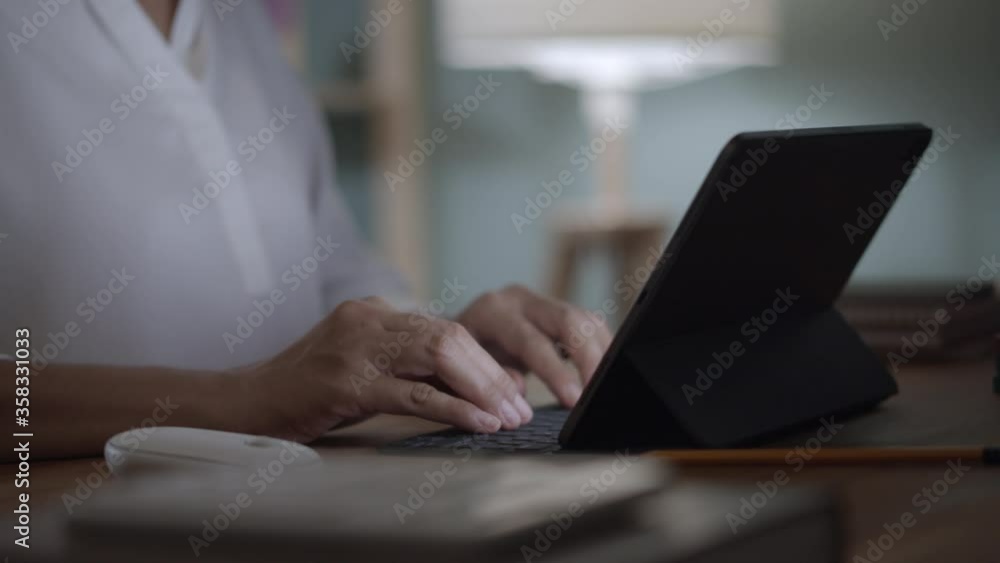 Hand of woman work from home using digital tablet at home night. Hand of woman work from home using digital tablet at home night.