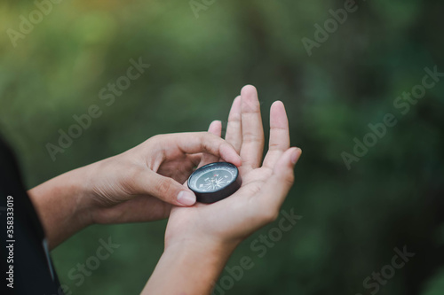 a man holding a compass in the forest