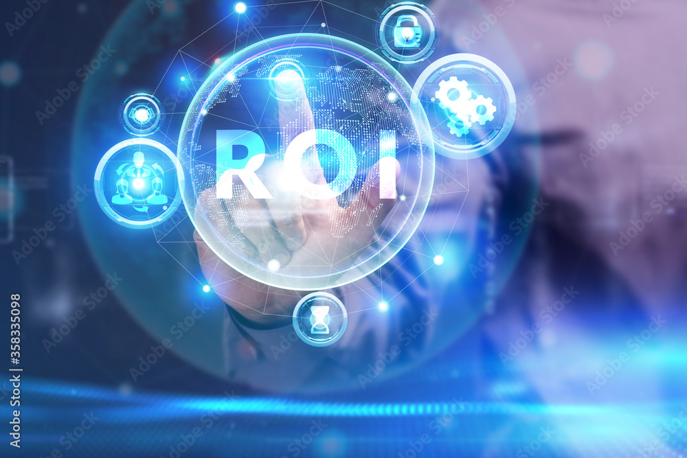 Business, Technology, Internet and network concept. Young businessman working on a virtual screen of the future and sees the inscription: ROI Business, Technology, Internet and network concept. Young businessman working on a virtual screen of the future and sees the inscription: ROI