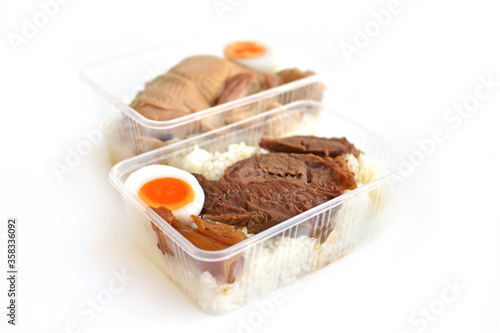 Stewed beef with rice in a plastic container ready to eat